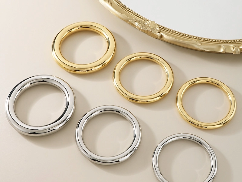 A collection of gold and silver polished stainless steel circular bracelets displayed on a neutral background.