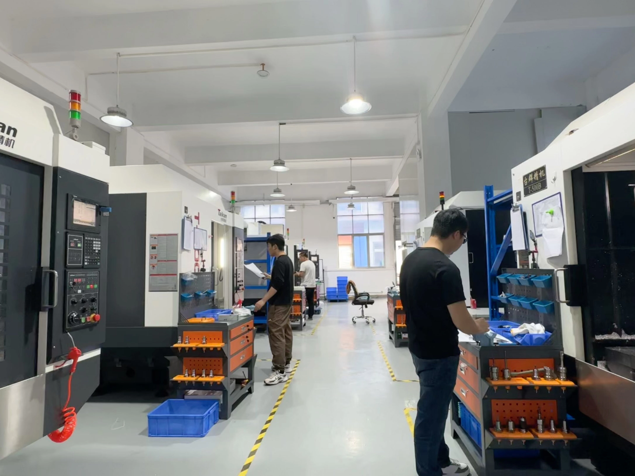 A stainless steel jewelry manufacturing workshop where workers operate CNC machines for precision processing and high-quality jewelry production.