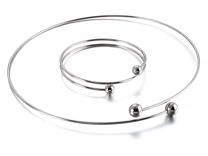 A minimalist stainless steel spiral bracelet and necklace set with polished ball accents, showcasing a sleek and contemporary design.