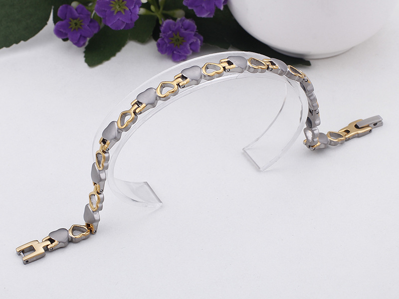 A romantic heart-link bracelet combining silver and gold tones, symbolizing elegance and love.