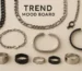 Flat lay of men’s fashion jewelry including chains, cuffs, and rings in stainless steel and black finishes.